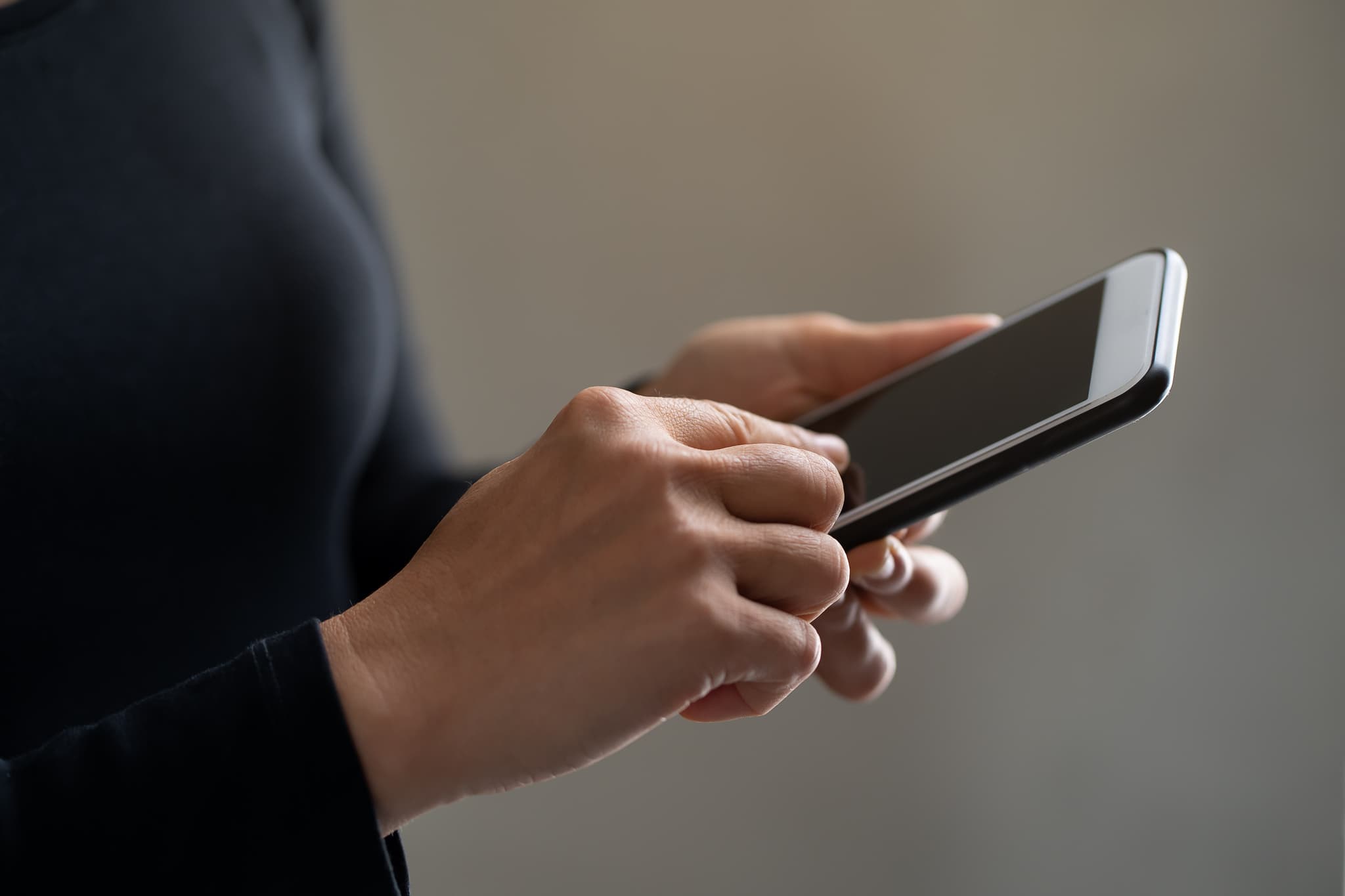 Sur l'image, nous voyons une personne en train de rmanipuler l'écran de son smartphone.